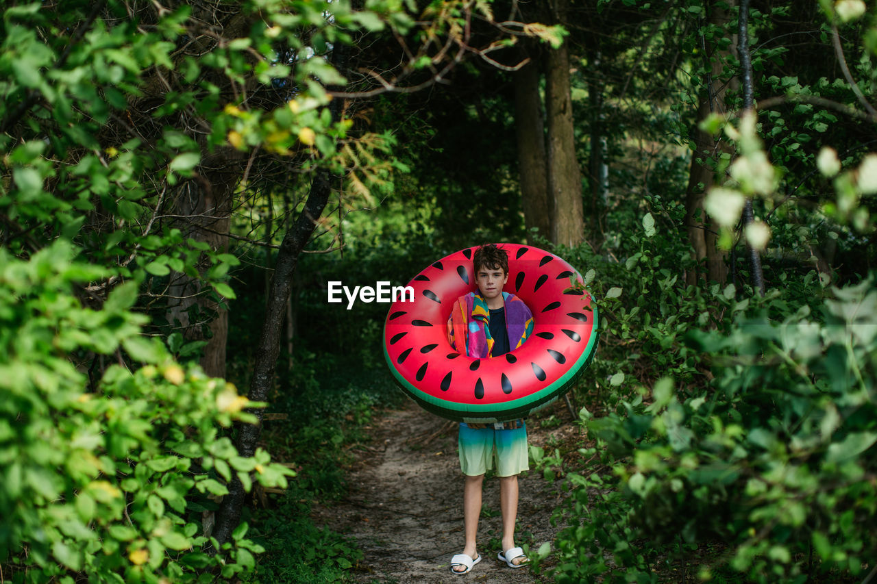 Teen boy with watermelon float ready for the beach