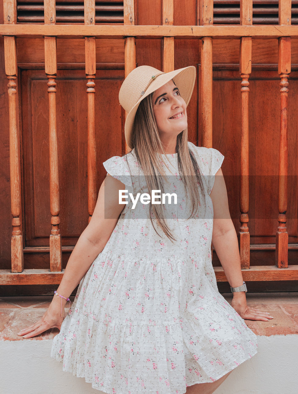 Young woman portrait smiling in white dress with a rustic door background from puerto rico san juan