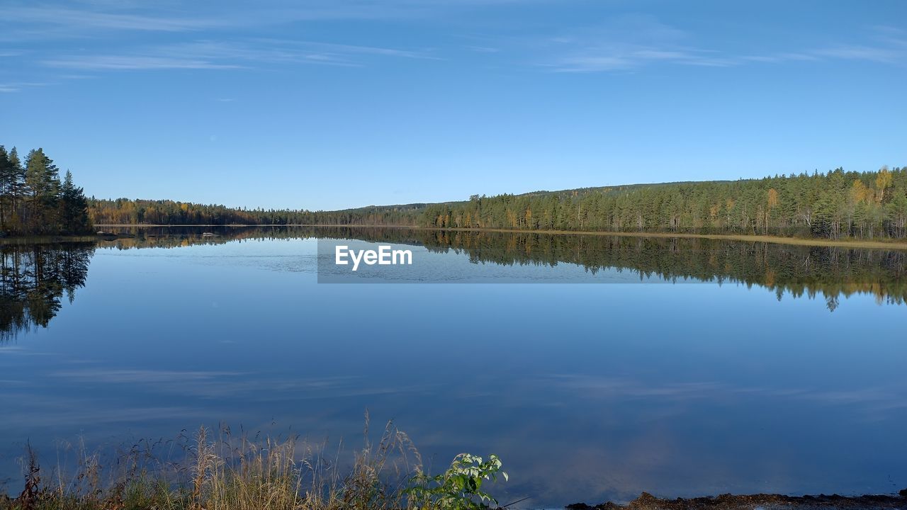 reflection, water, lake, nature, body of water, scenics - nature, sky, beauty in nature, tranquility, wilderness, tree, plant, reservoir, tranquil scene, landscape, environment, no people, blue, land, forest, autumn, non-urban scene, travel destinations, outdoors, morning, day, mountain, travel, cloud, tourism, idyllic, clear sky, beach, shore