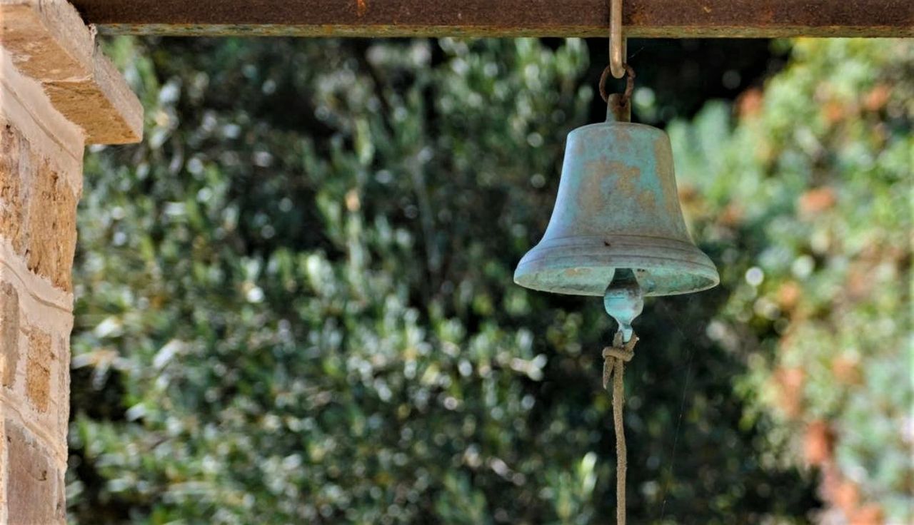 Low angle view of bell hanging against trees
