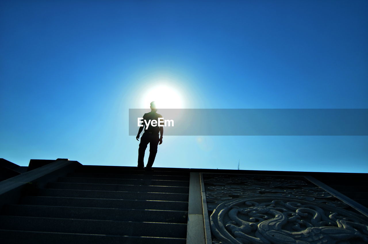 Low angle view of man on steps against sky