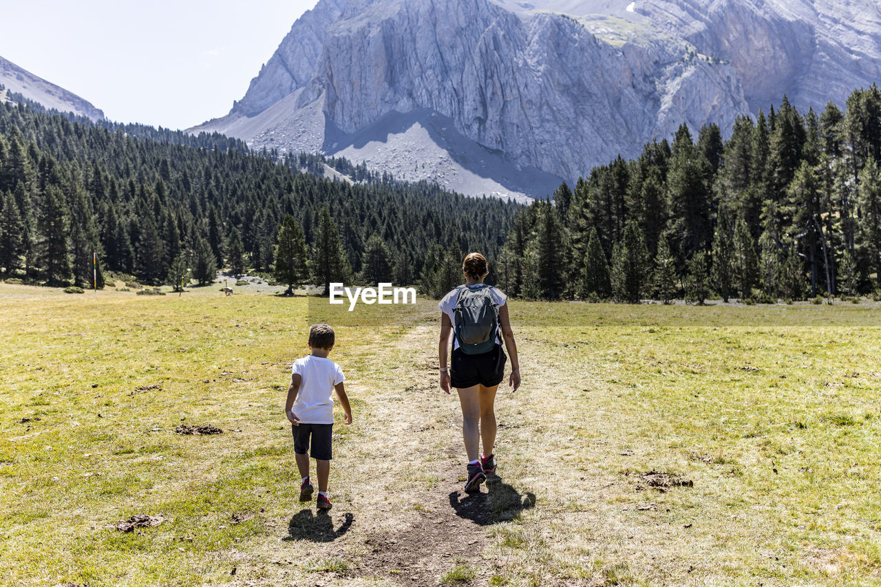 Rear view of man and woman walking on mountain