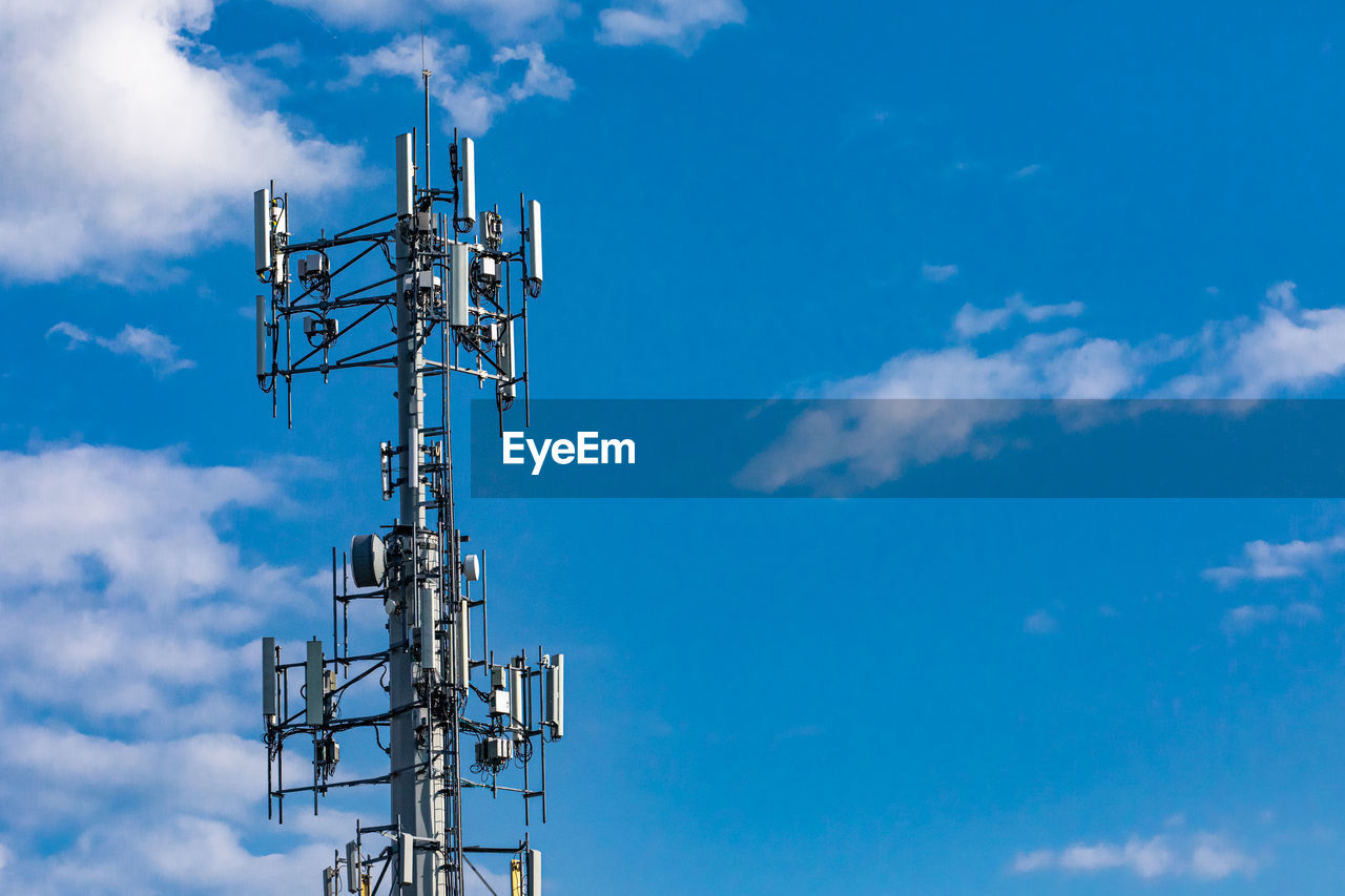 Low angle view of communications tower against blue sky