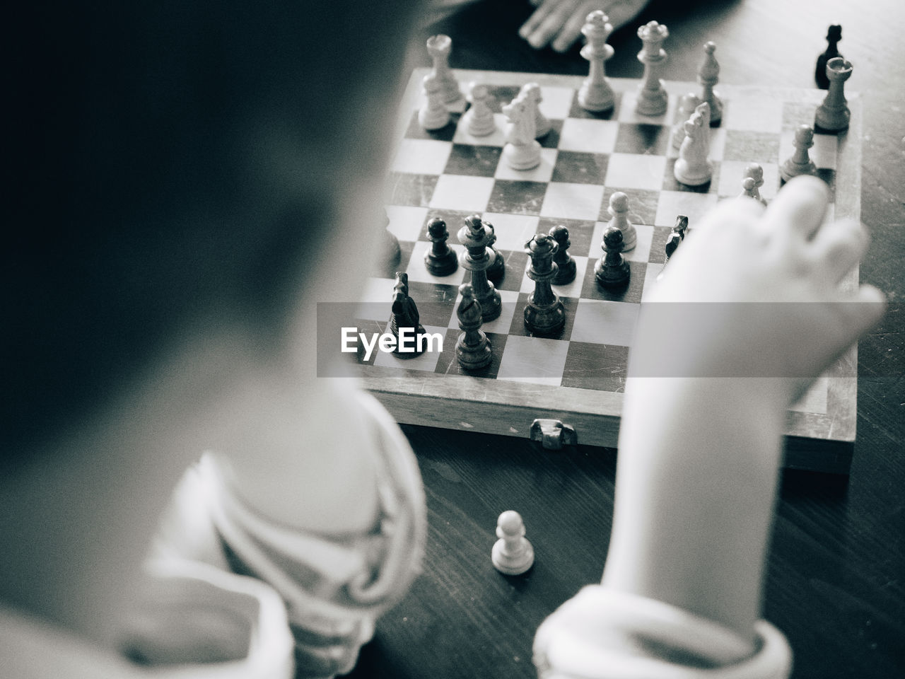 Cropped image of boy playing chess at table