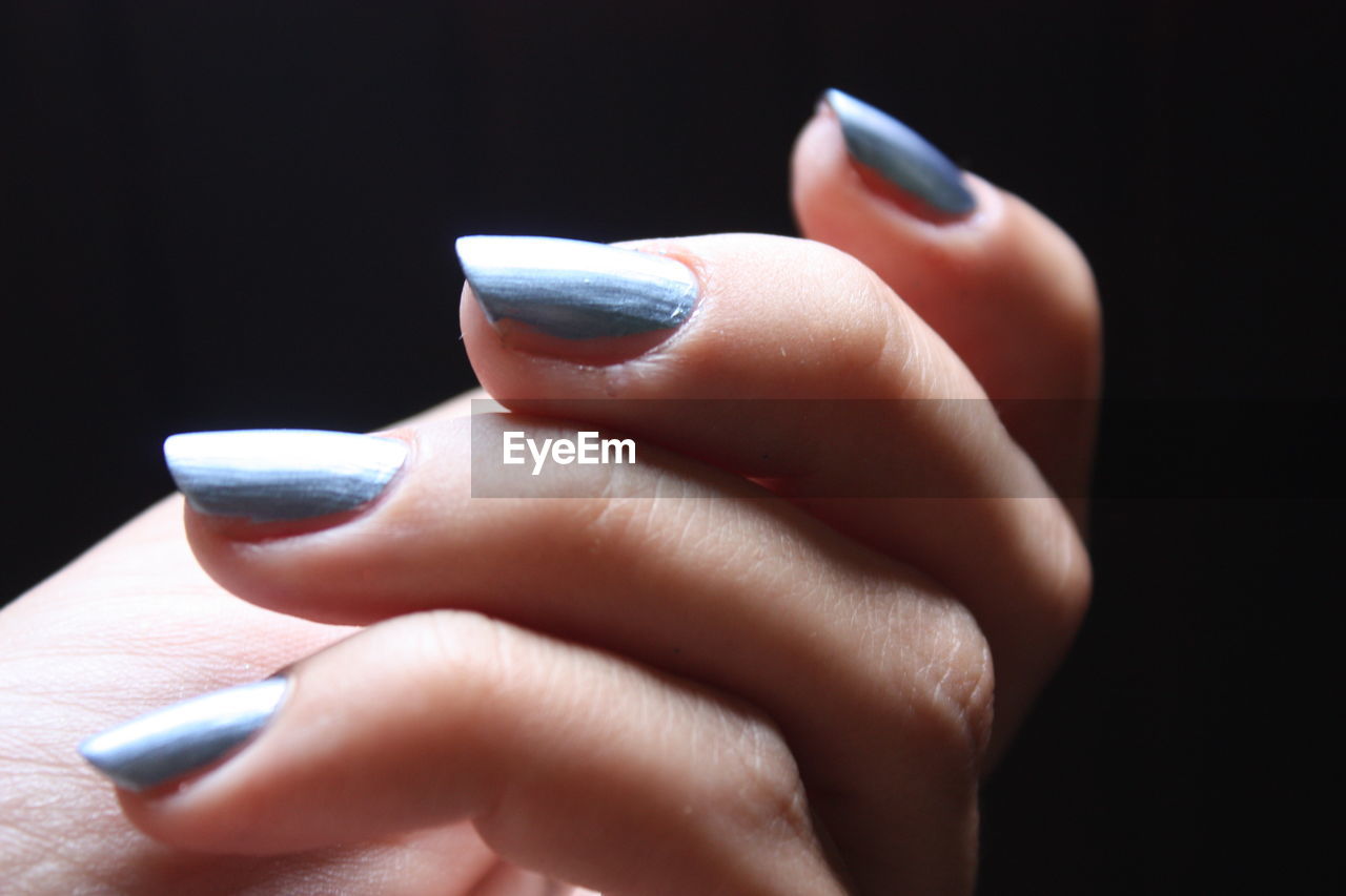 Close-up of woman hand over black background