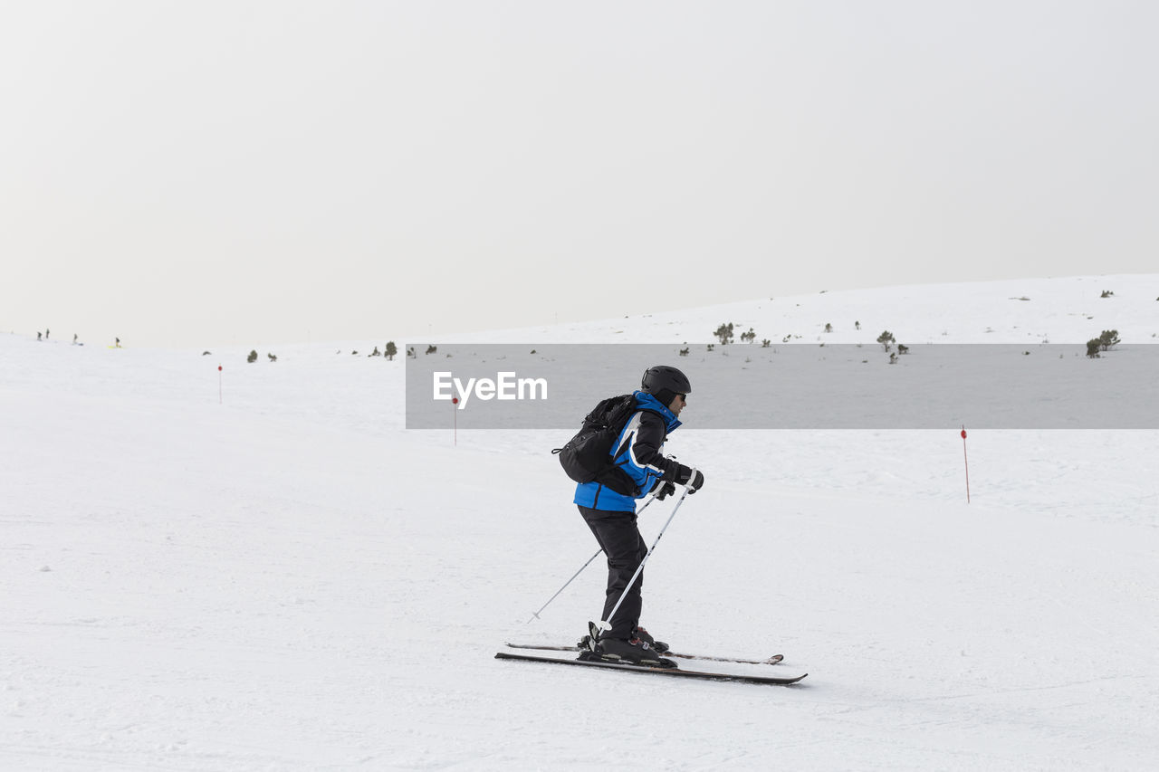 Side view of man skiing on snowcapped mountain