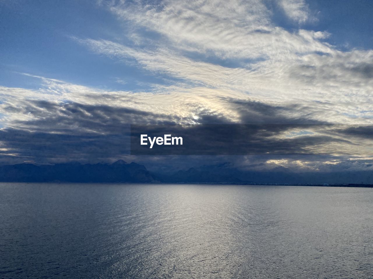 sky, water, horizon, cloud, scenics - nature, beauty in nature, sea, tranquility, nature, tranquil scene, no people, reflection, ocean, environment, blue, sunlight, outdoors, body of water, idyllic, landscape, day, cloudscape, coast, dramatic sky, dusk, seascape, travel, mountain, shore