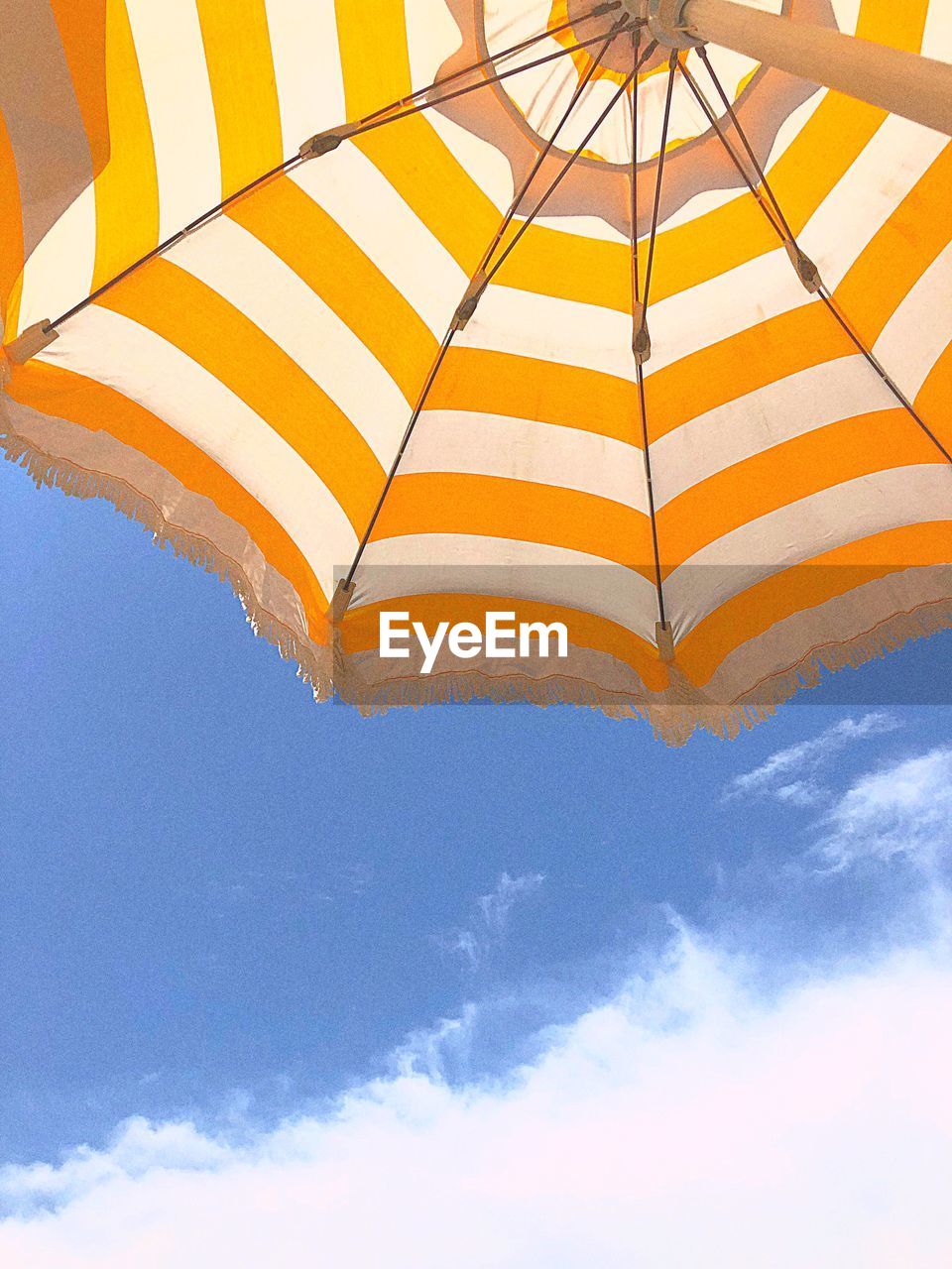 Low angle view of umbrella against blue sky