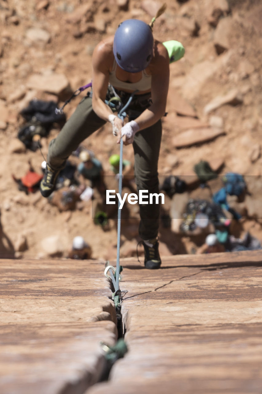 High angle view of female hiker clambering on mountain