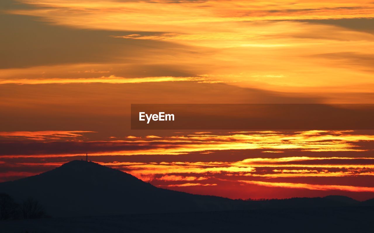 SCENIC VIEW OF SILHOUETTE MOUNTAINS AGAINST ROMANTIC SKY