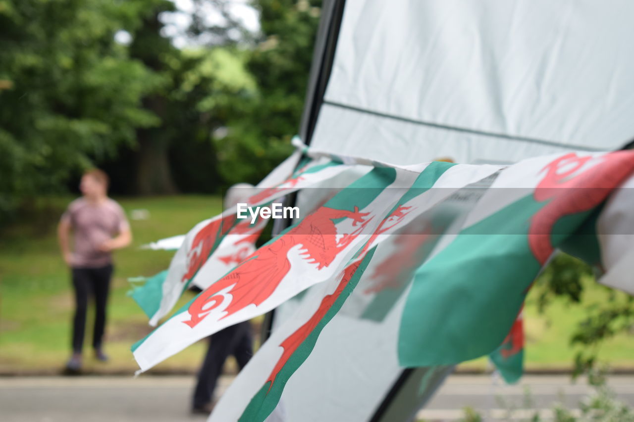 REAR VIEW OF WOMAN WITH UMBRELLA WALKING IN FLAG