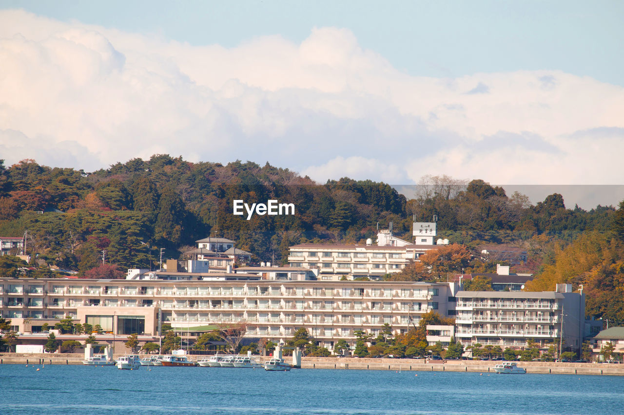 Scenic view of sea by buildings against sky