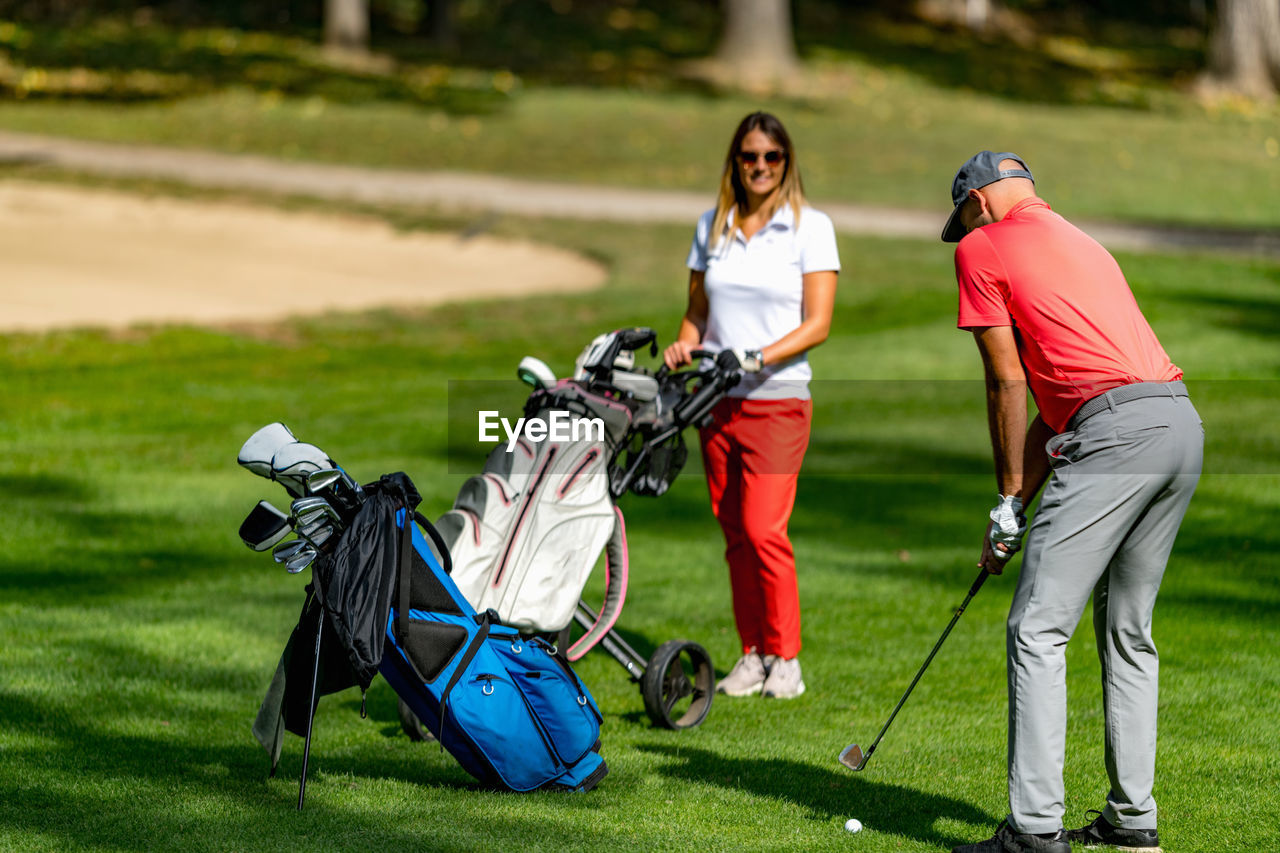 Young couple playing golf on a beautiful summer day