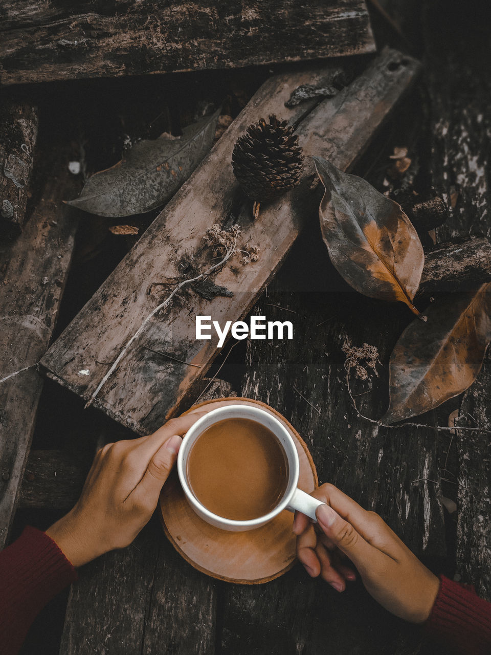 High angle view of hand holding coffee cup