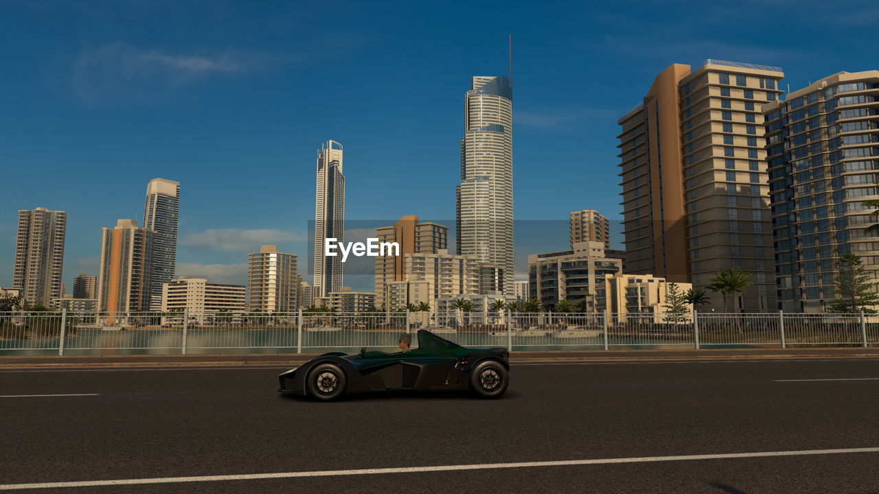 CARS ON ROAD BY BUILDINGS AGAINST SKY