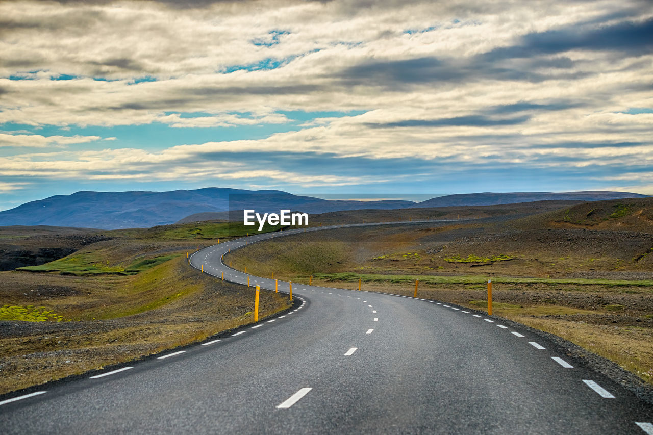 ROAD PASSING THROUGH MOUNTAINS AGAINST SKY