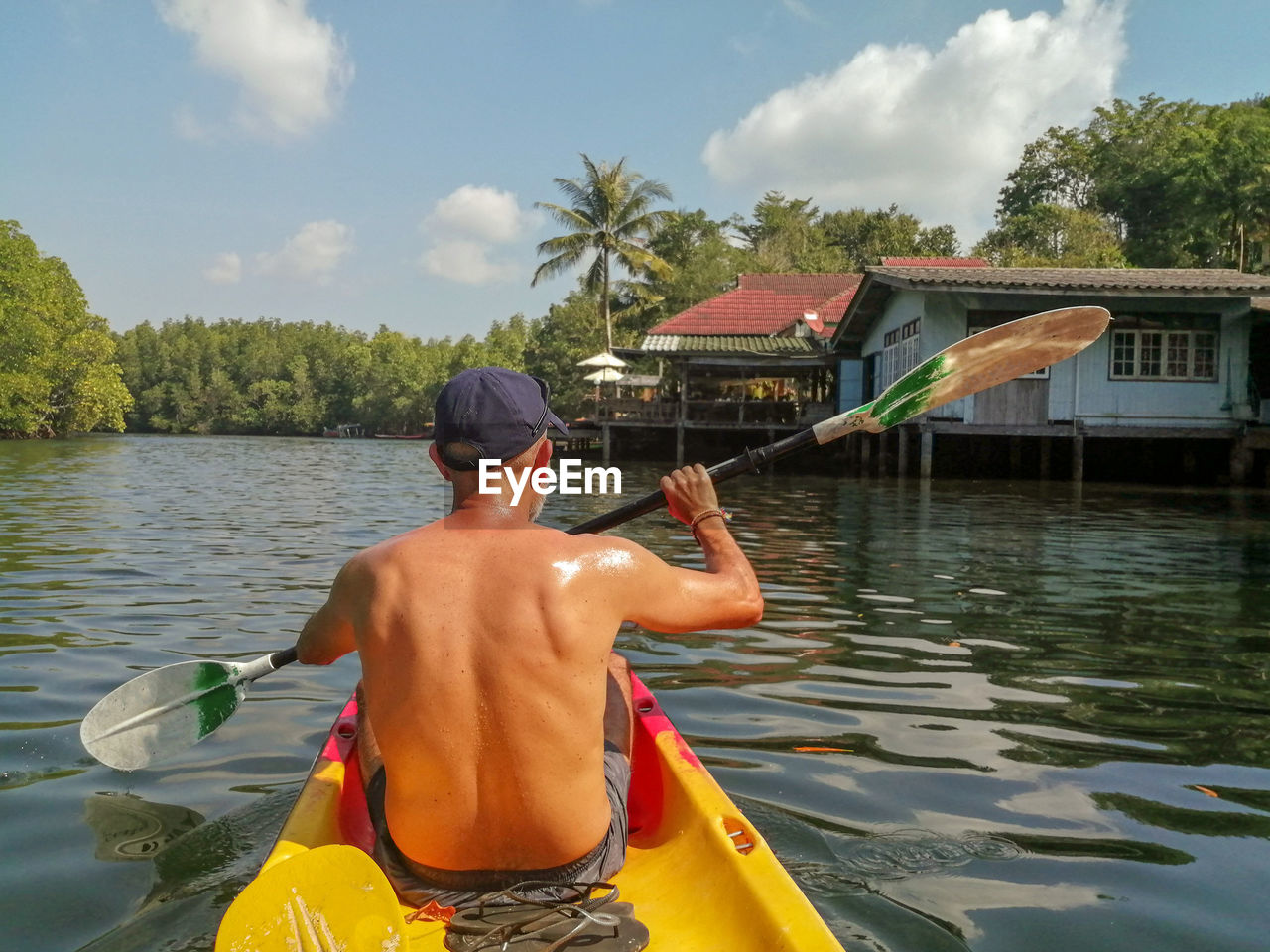 REAR VIEW OF SHIRTLESS MAN IN LAKE