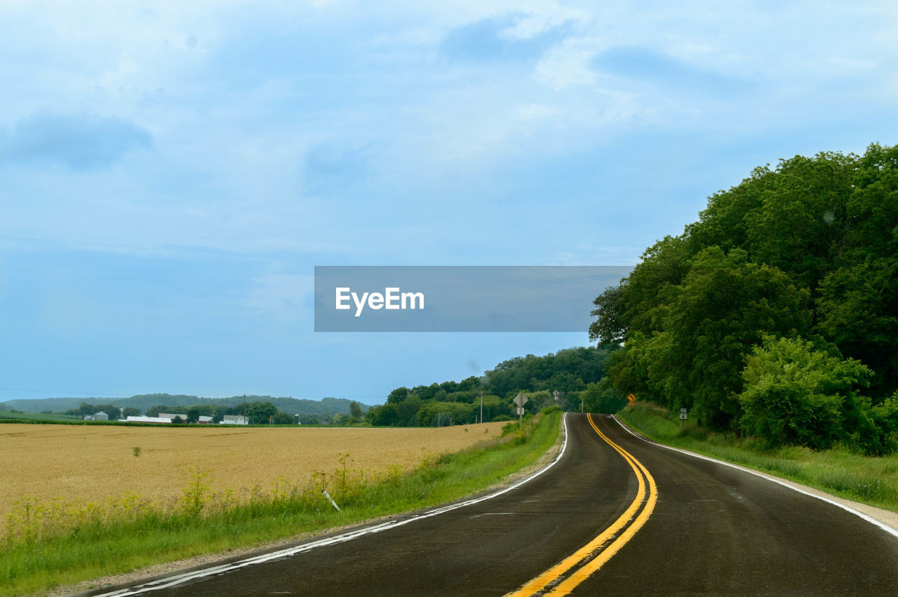 Road passing through landscape against sky