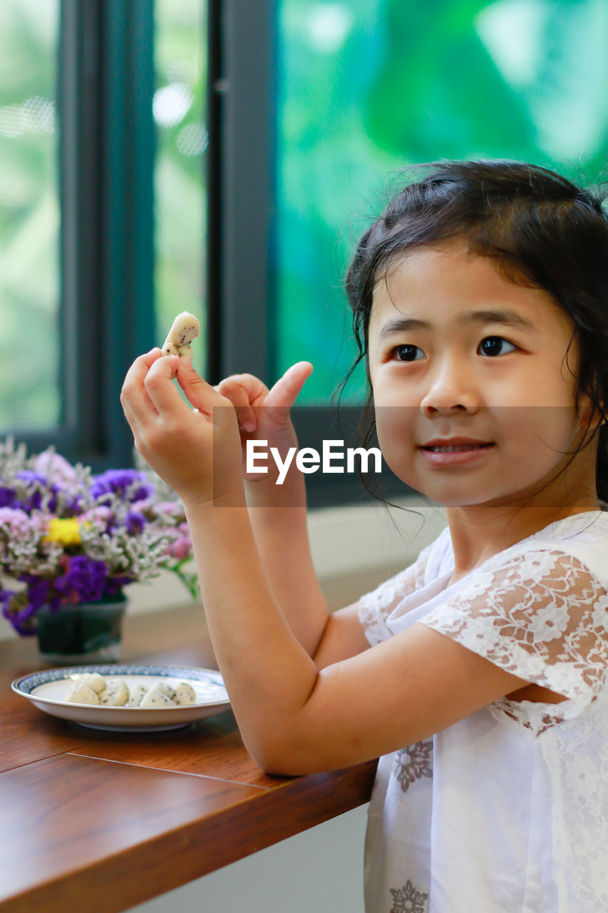 Portrait of cute girl on table