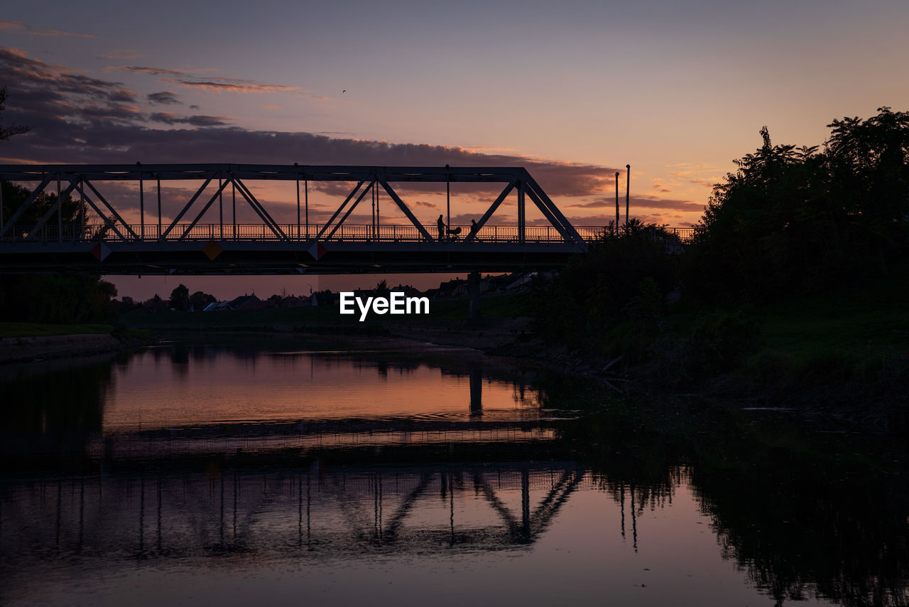 bridge over river at sunset