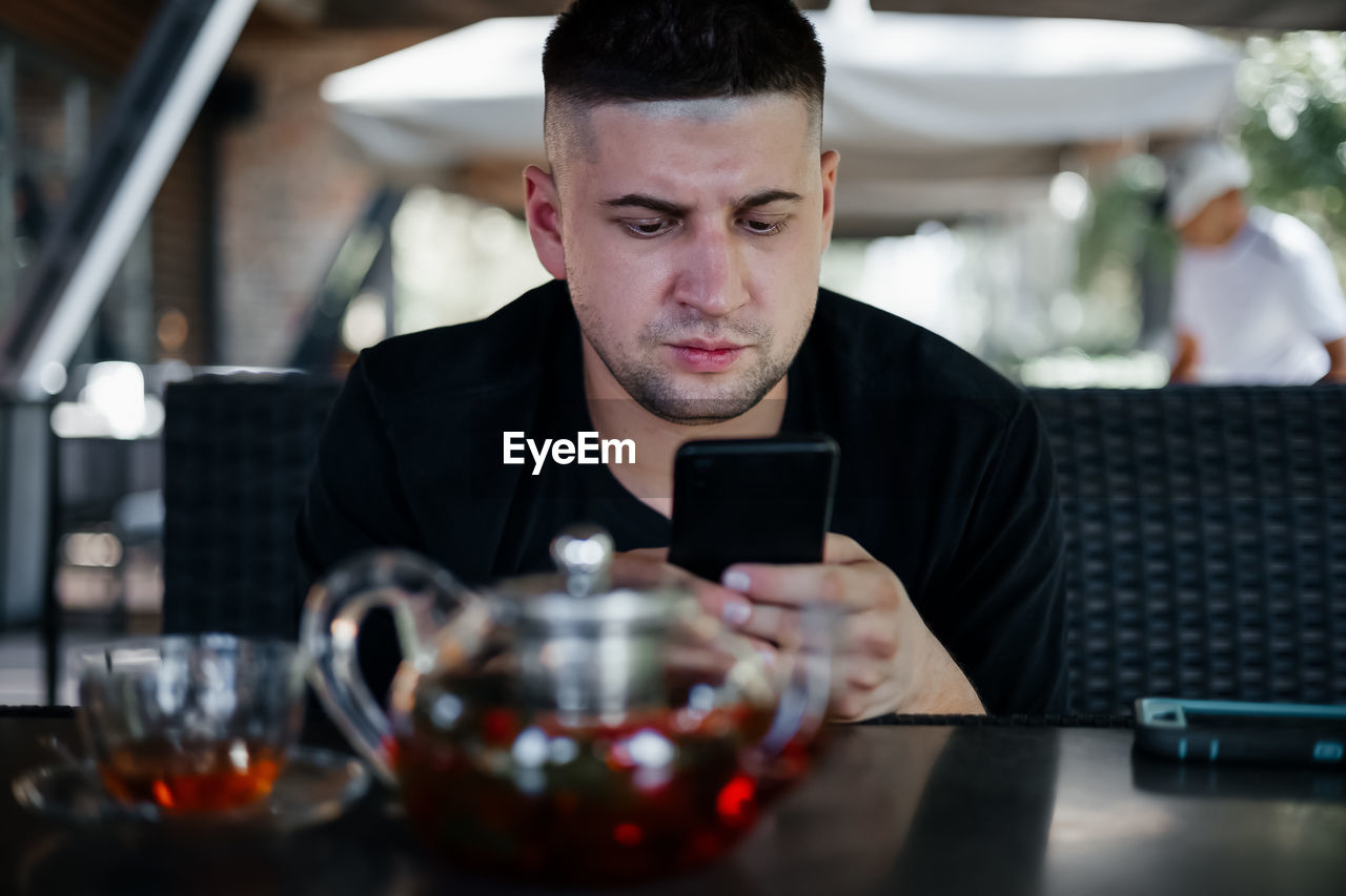 Young man watching smartphone in cafe . freelance concept
