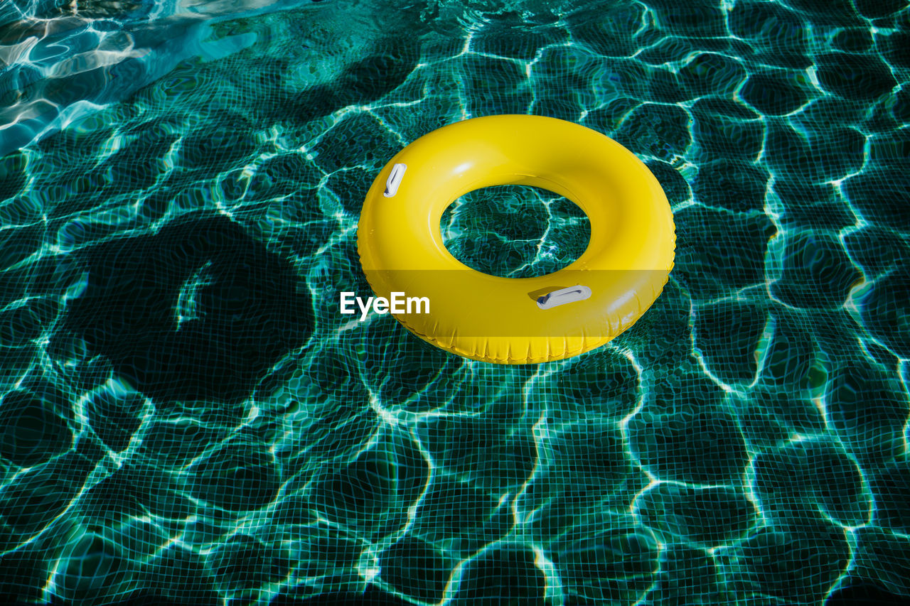 Yellow inflatable donuts floating in a swimming pool. nobody. summer time concept