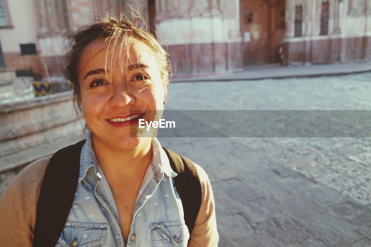 Portrait of smiling young woman in city