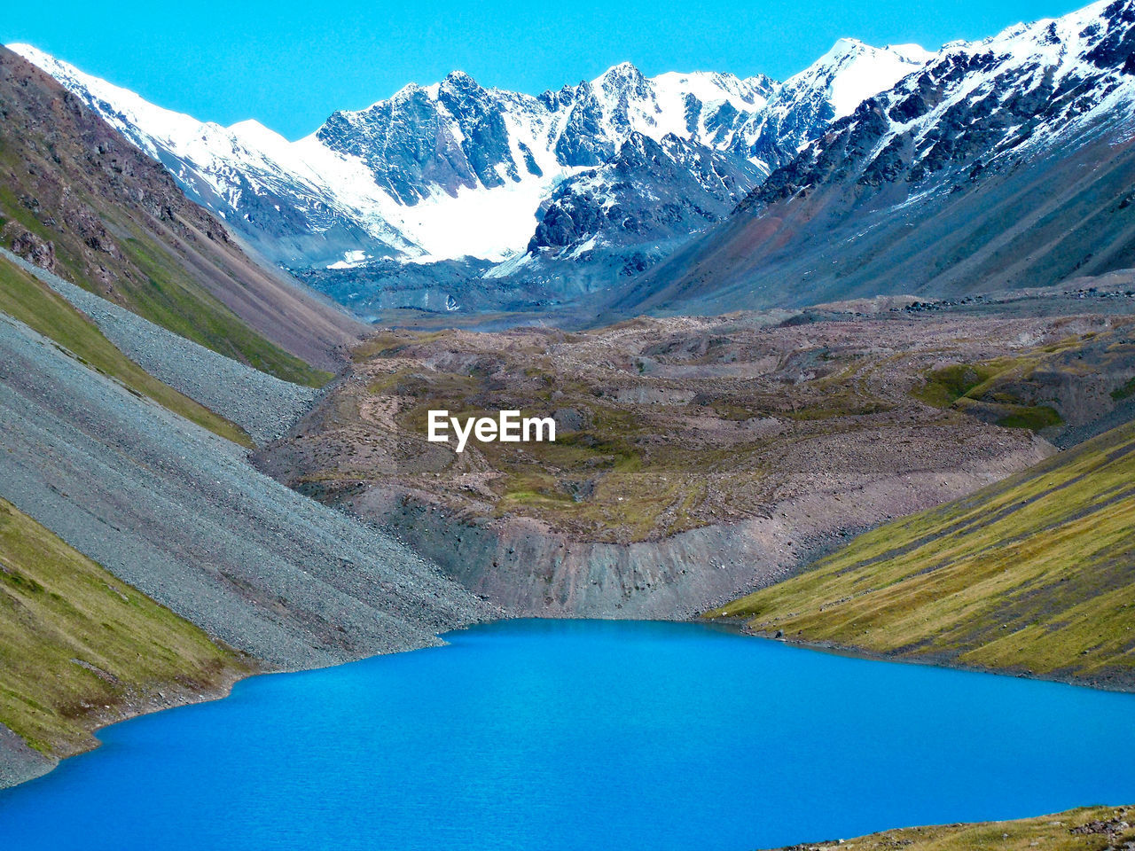 HIGH ANGLE VIEW OF LAKE AMIDST SNOWCAPPED MOUNTAINS AGAINST SKY