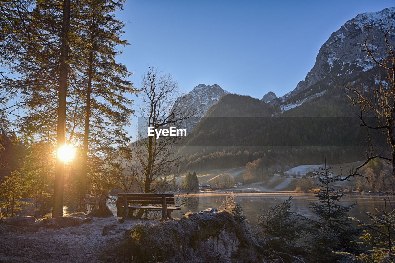 Scenic view of lake by mountains against clear sky