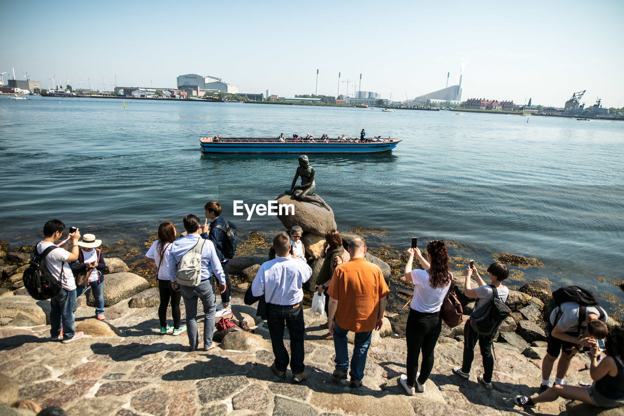 PEOPLE ON HARBOR AGAINST SKY