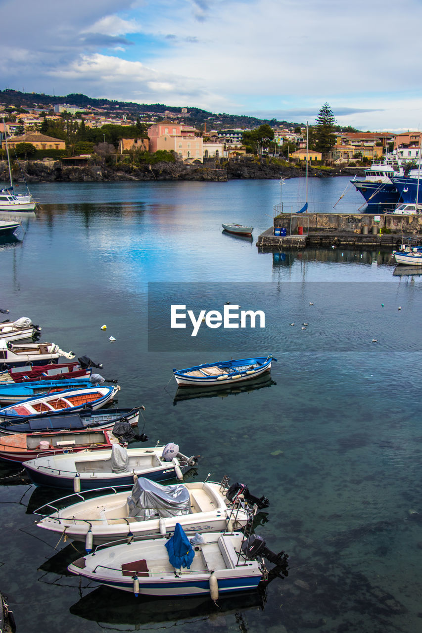 High angle view of boats moored at harbor against sky