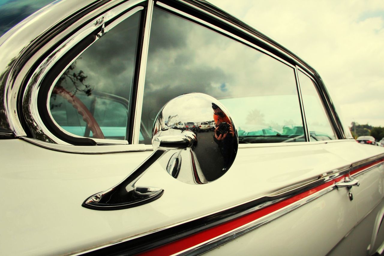 Reflection on side-view mirror of car on street