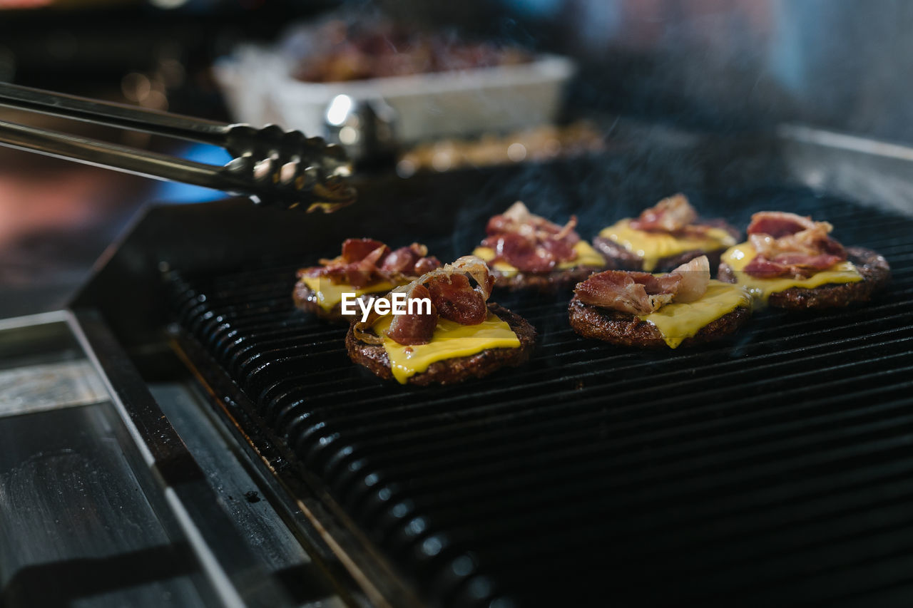 CLOSE-UP OF MEAT COOKING ON BARBECUE