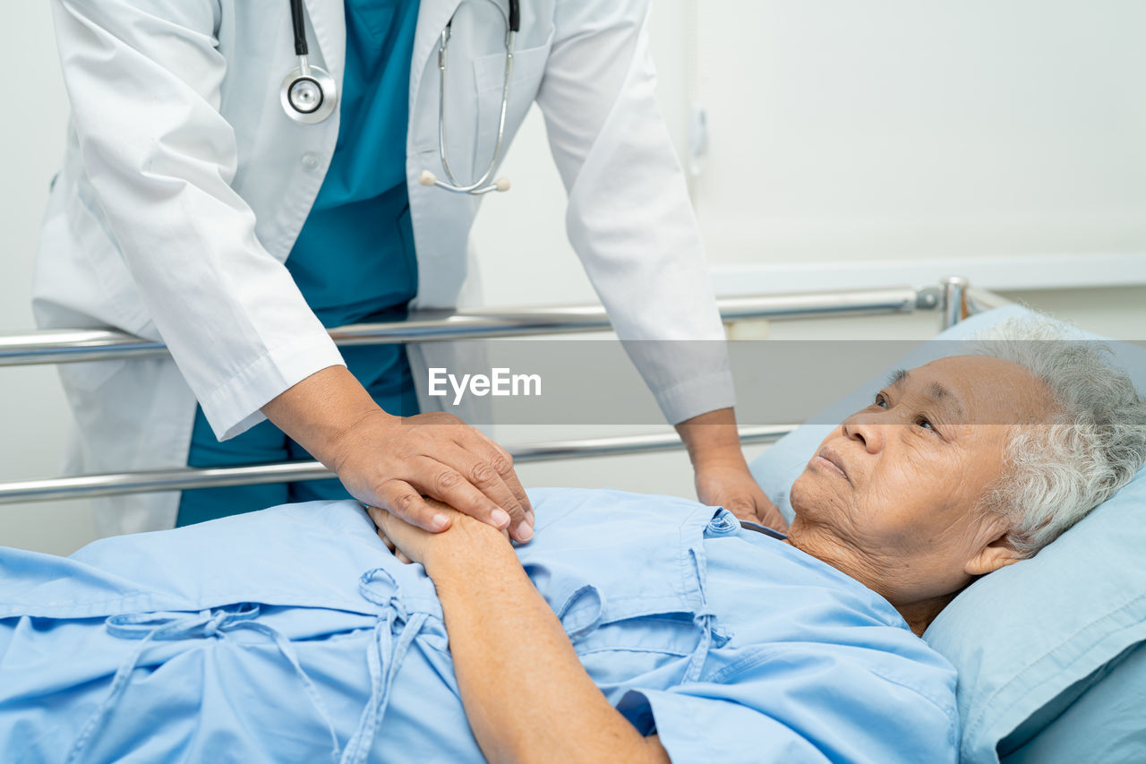 Holding hands asian senior or elderly old lady woman patient with love, care, encourage and empathy 