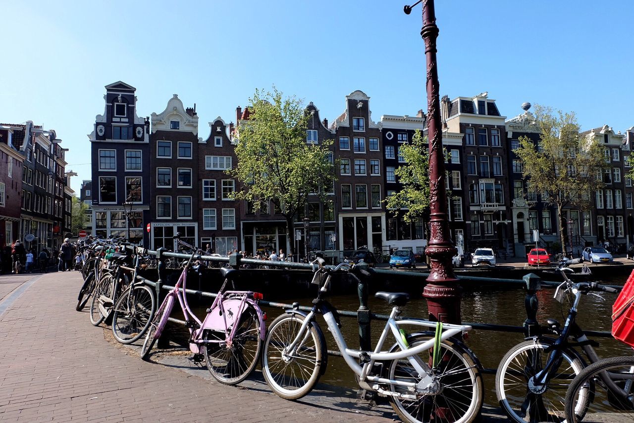 Bicycles parked in city against clear sky