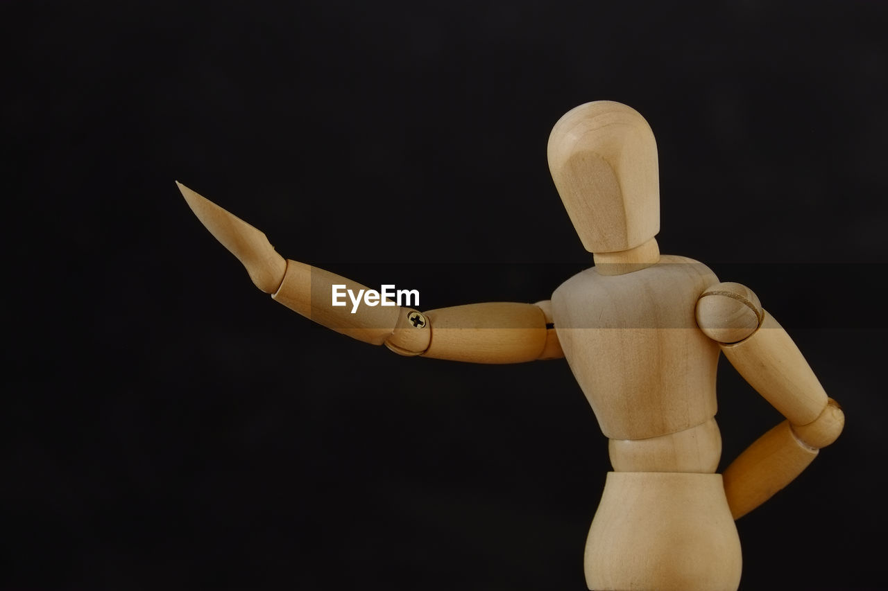 Wooden mannequin against black background