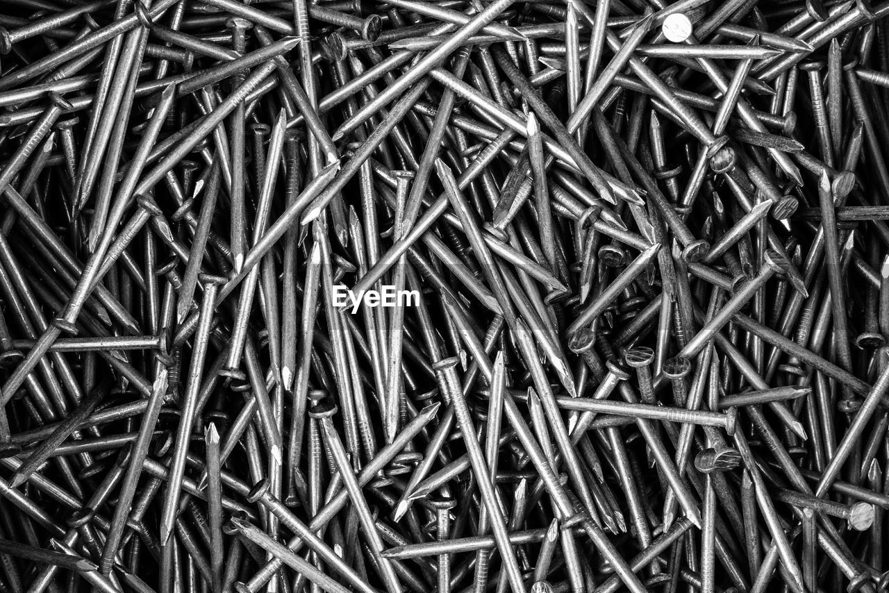 A bunch of metal nails close-up top view, black and white photo