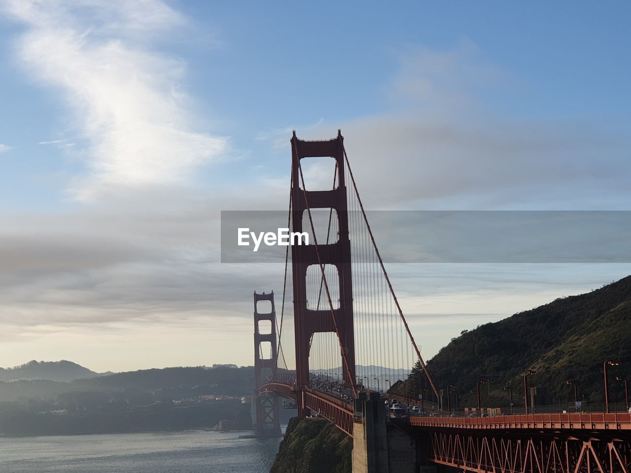 View of suspension bridge against cloudy sky