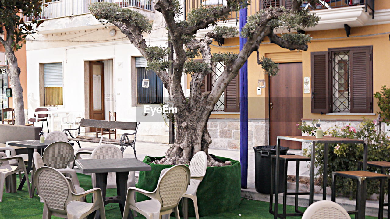 EMPTY CHAIRS AND TABLES AT CAFE