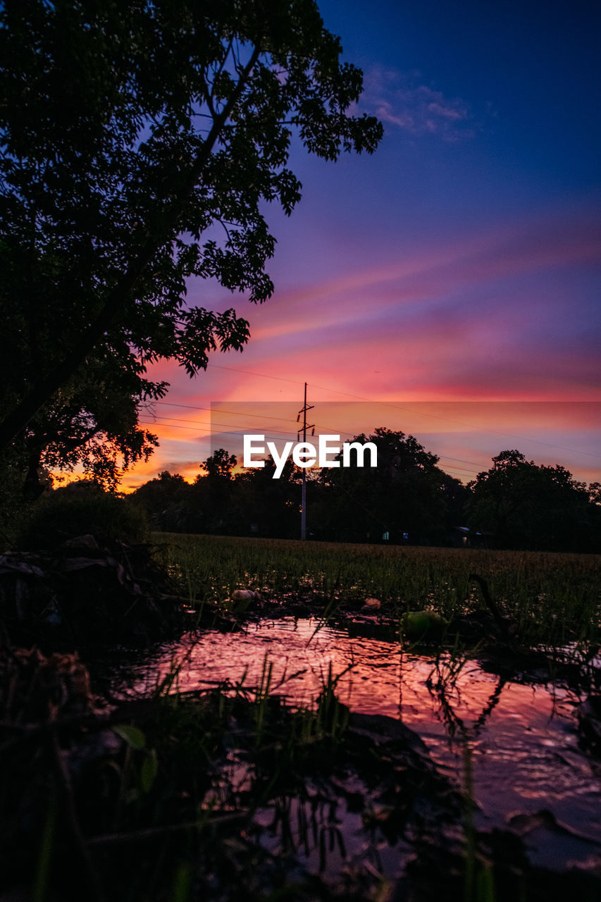 SCENIC VIEW OF LAKE AGAINST ORANGE SKY