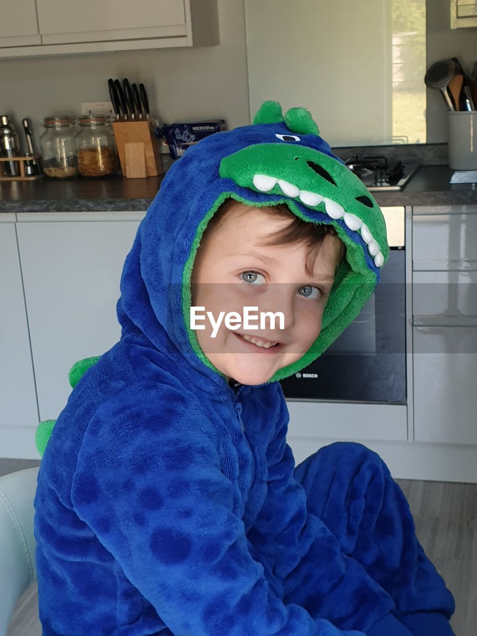 Portrait of smiling boy in costume sitting at home