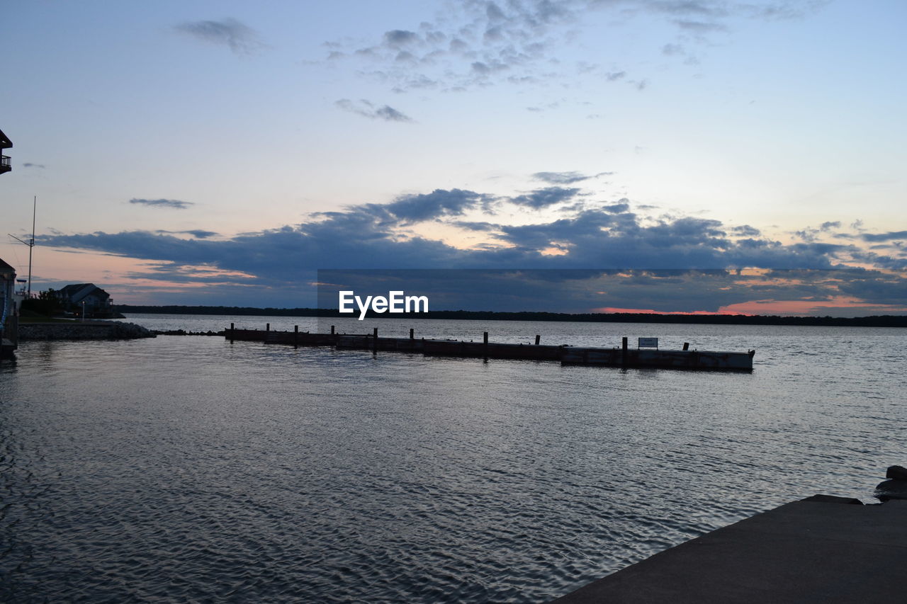 Pier over sea against sky during sunset