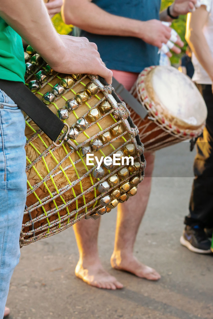 Low section of people playing musical equipment while standing on street