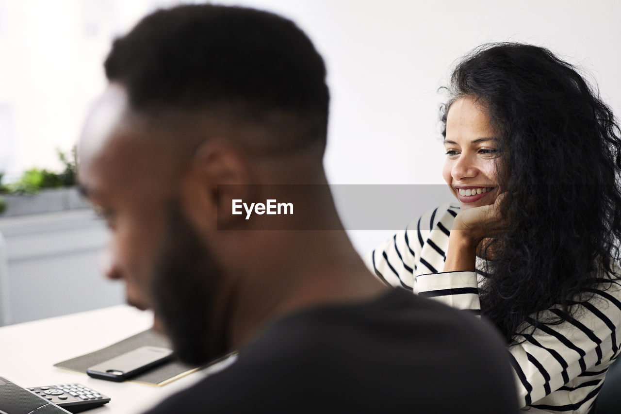 Smiling businesswoman working with male colleague in office