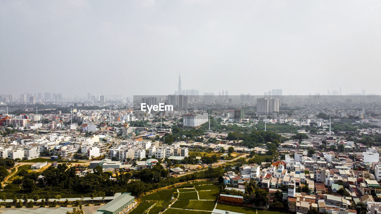 HIGH ANGLE VIEW OF CITY AND BUILDINGS AGAINST SKY