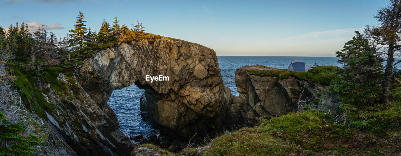 Rocks by sea against sky