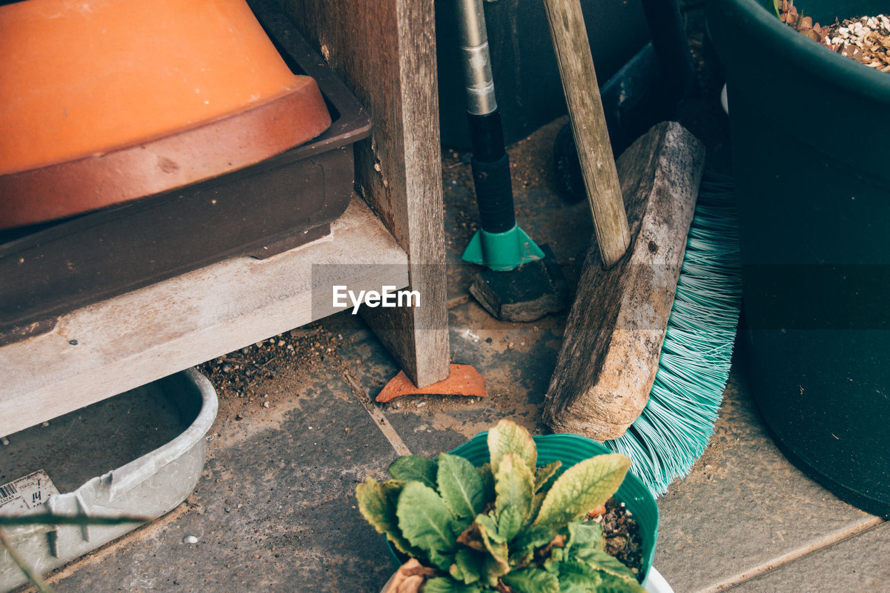 High angle view of broom and potted plant by old cabinet