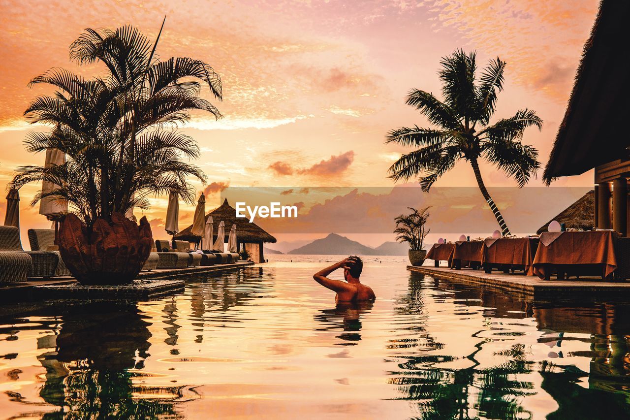 Young men swimming pool during sunset sey6