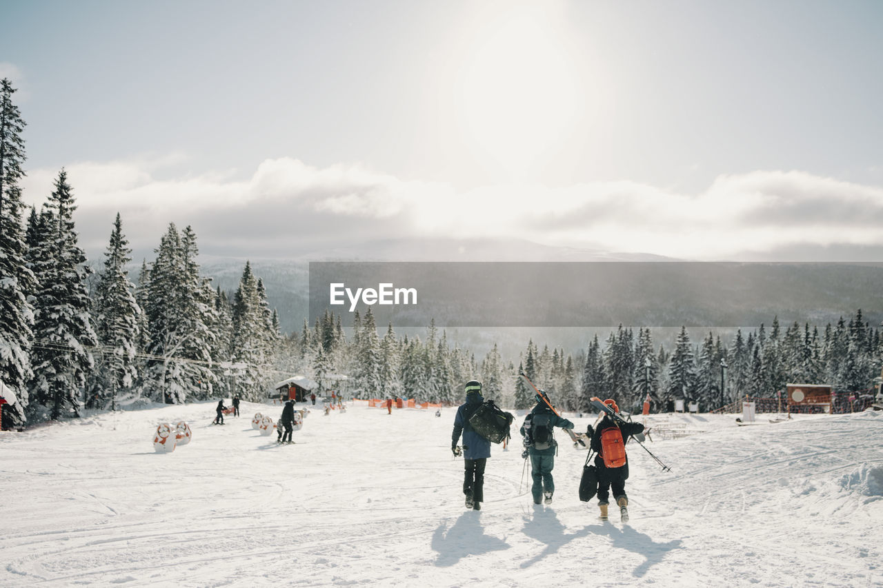 Male and female friends walking at tourist resort during winter