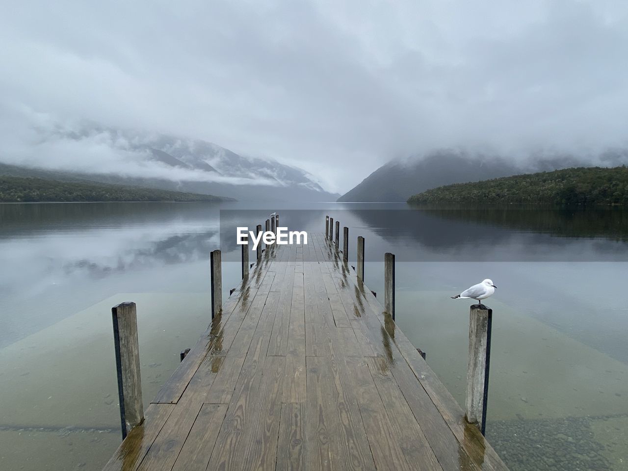 Pier over lake against sky